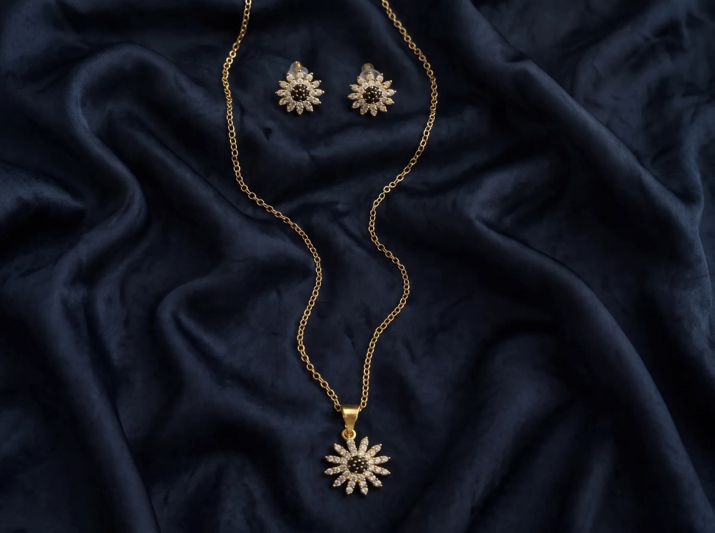 The Celeste starburst gold pendant necklace and matching stud earrings