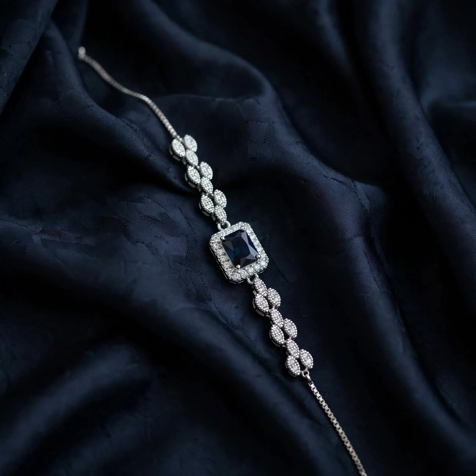 The Noir Bracelet with emerald-cut dark sapphire halo and pave leafy links by Azor