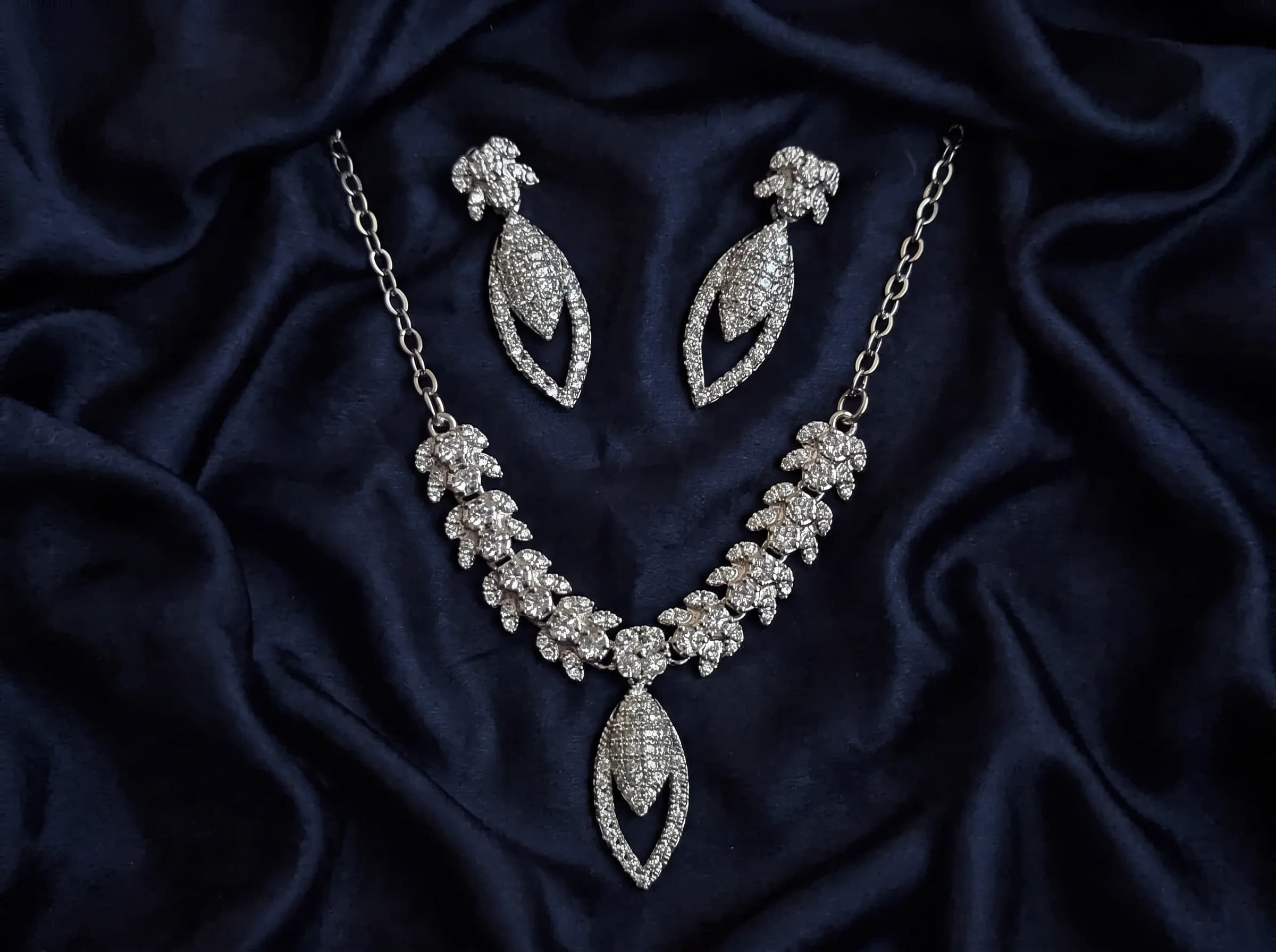 Model wearing collarbone pendant necklace against dark fabric