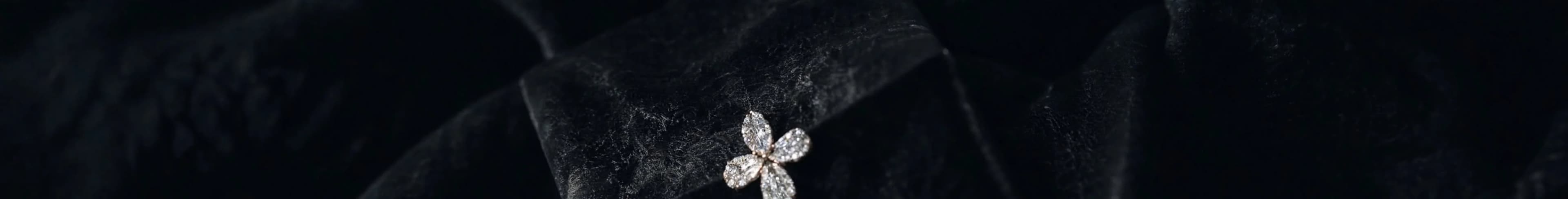 Dark silk fabric with Azor fine jewelry in ambient light